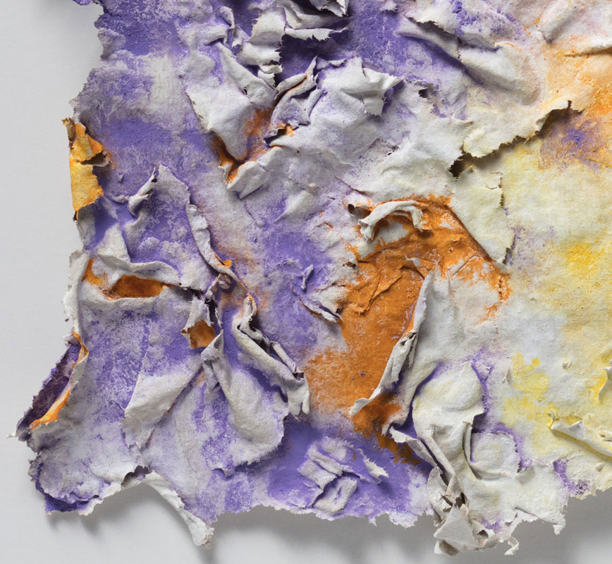 Detail of an abstract textural work on paper tridimentionally cast by the artist. Mainly yellow, orange, and purple colors. Title: Solstitium (Summer Solstice)