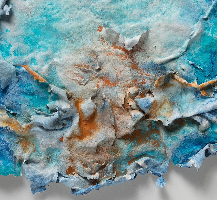 Detail of an abstract textural work on paper tridimentionally cast by the artist. Mainly turquoise and orange colors. Title: Aurora Vernum (Spring Dawn)