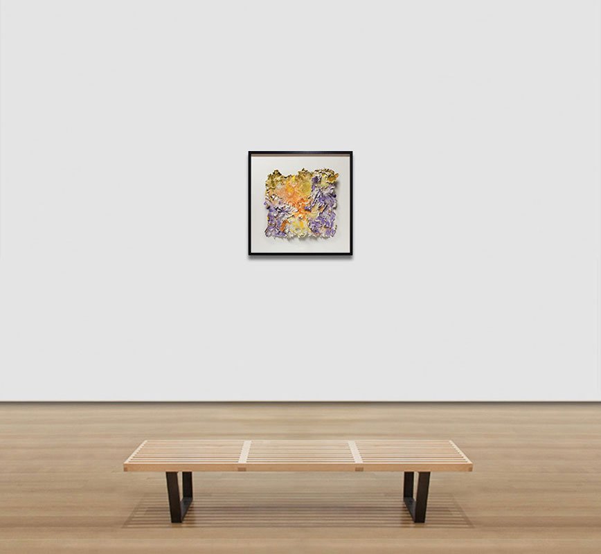 View in a room of an abstract textural work on paper tridimentionally cast by the artist. Mainly yellow, orange, and purple colors. Title: Solstitium (Summer Solstice)