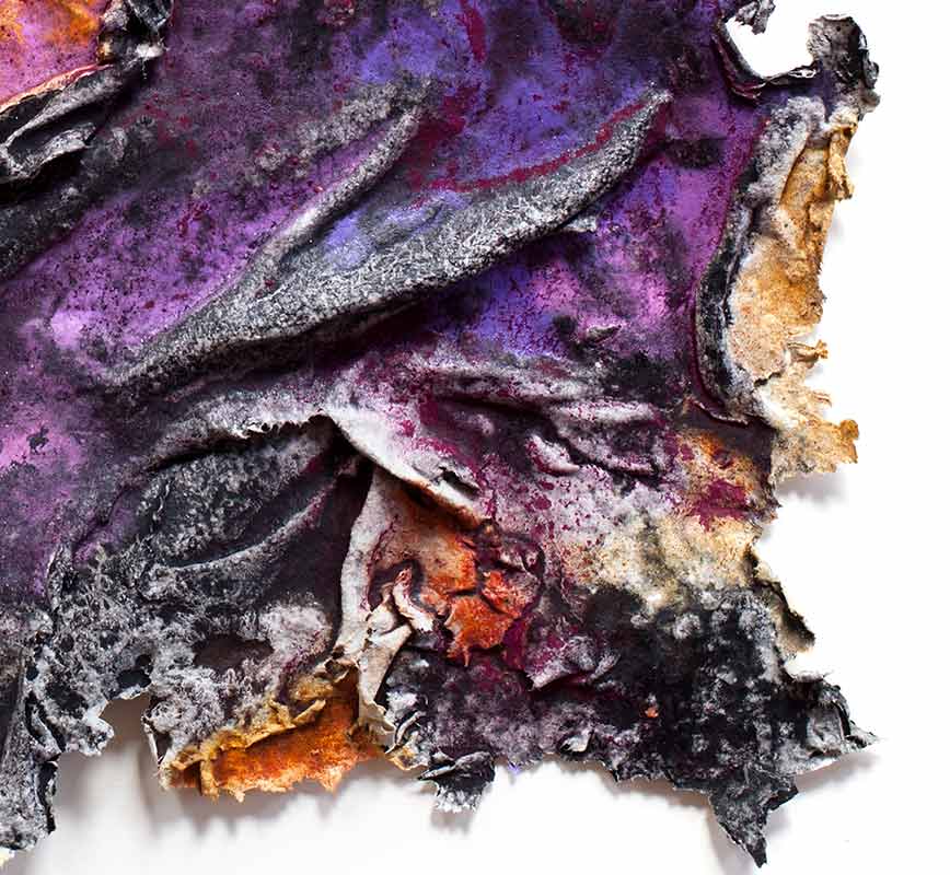 Detail of an abstract textural work on paper tridimentionally cast by the artist. Mainly purple colors. Title: Charta: Ater et Indicus