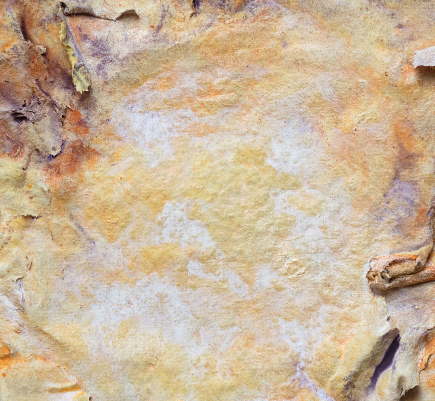 Detail of an abstract textural work on paper tridimentionally cast by the artist. Mainly yellow and brown colors. Title: Estate Lux (Summer Light)