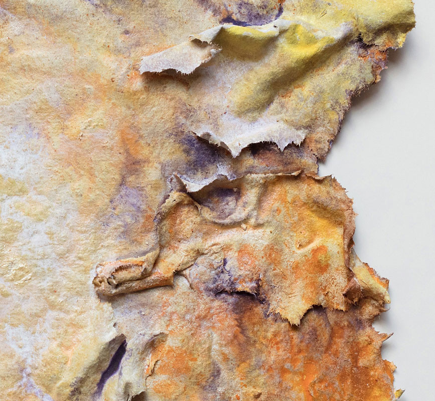 Detail of an abstract textural work on paper tridimentionally cast by the artist. Mainly yellow and brown colors. Title: Estate Lux (Summer Light)