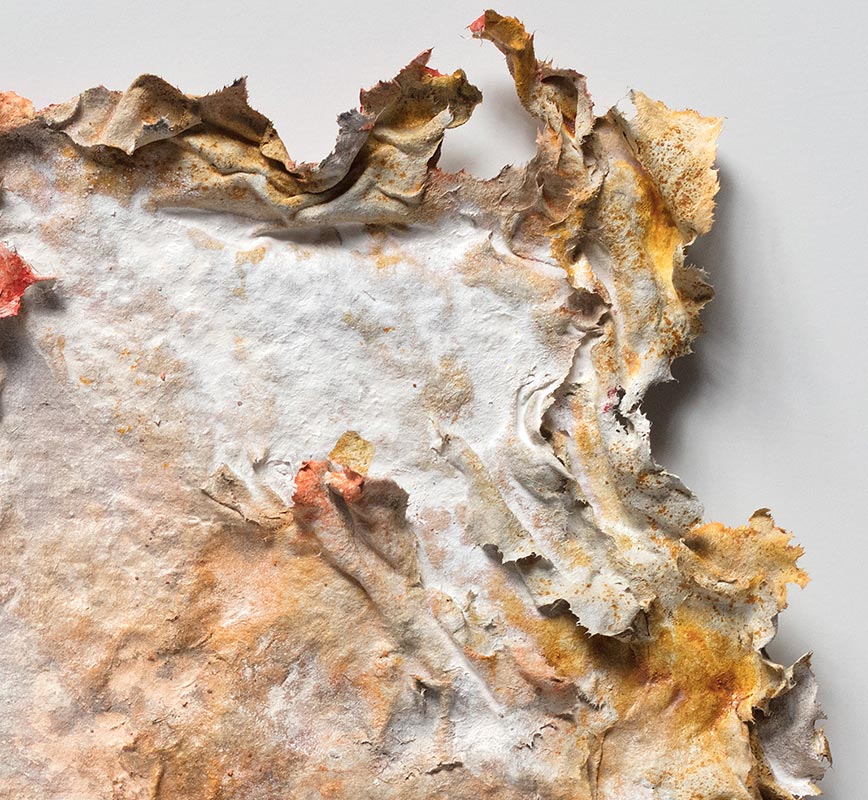 Detail of an abstract textural work on paper tridimentionally cast by the artist. Mainly orange and brown colors. Title: Aequinoctium Autumnale (Fall Equinox)